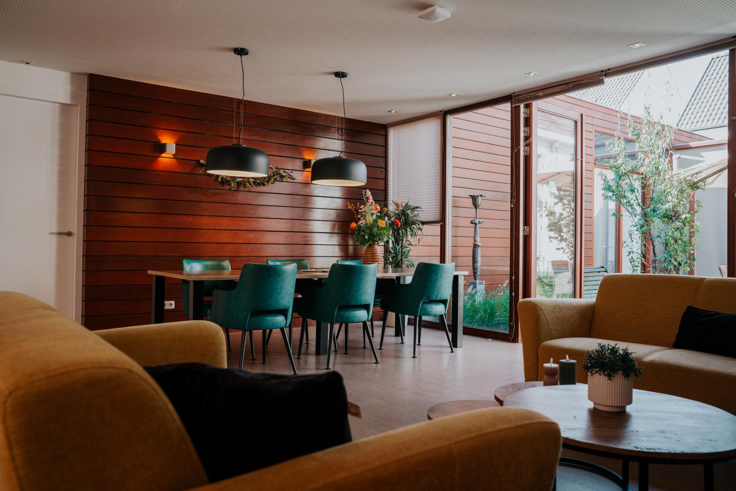 Woonkamer met twee banken een tafel en zes stoelen